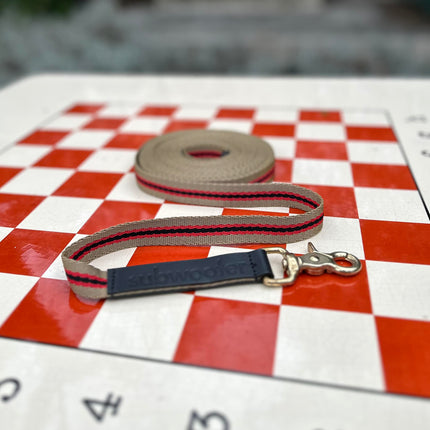 sand-red-and-black-striped-recall-line for-dog-on-a-red-and-cream-checkerboard-in-a-paris-park